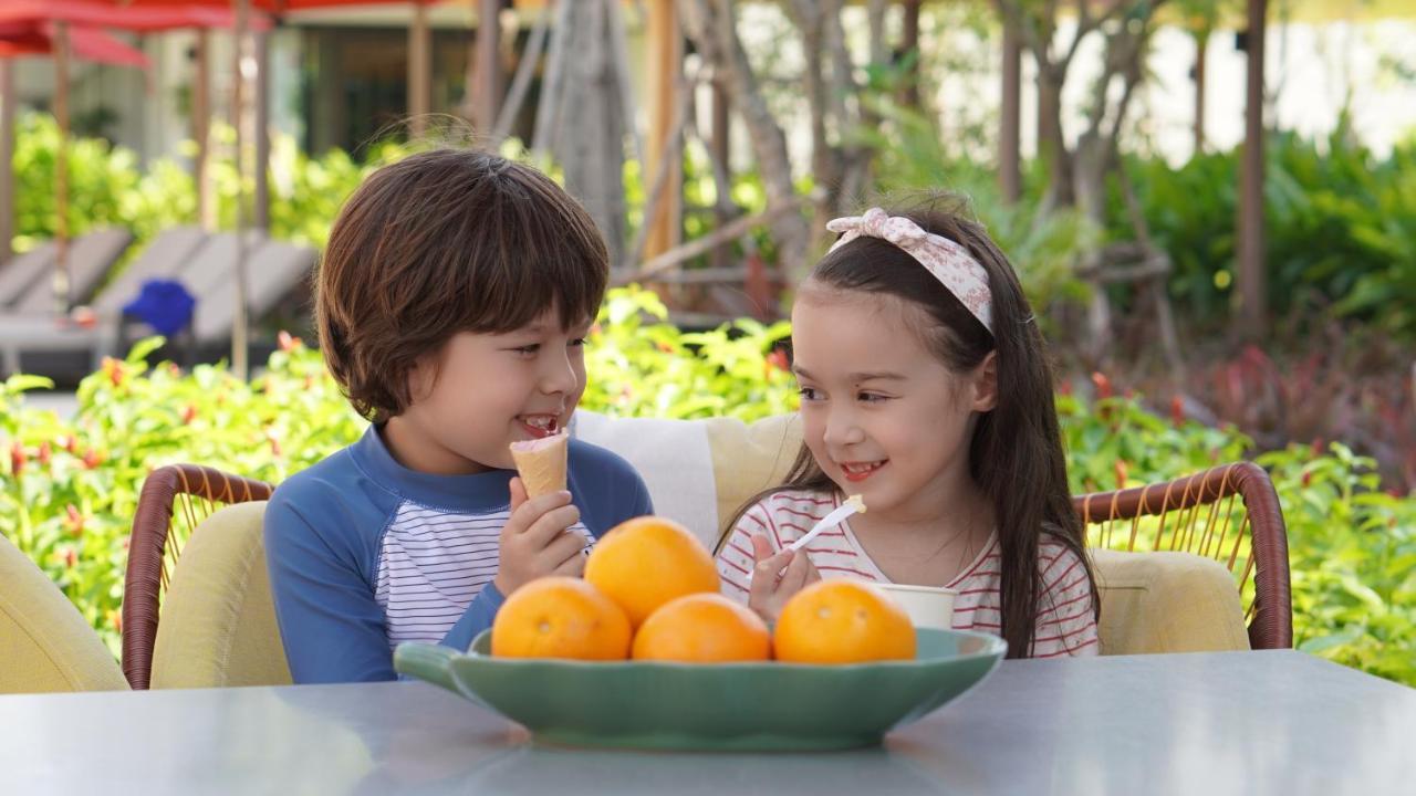 Amari Pattaya Hotel Luaran gambar A boy and a girl eating fruit